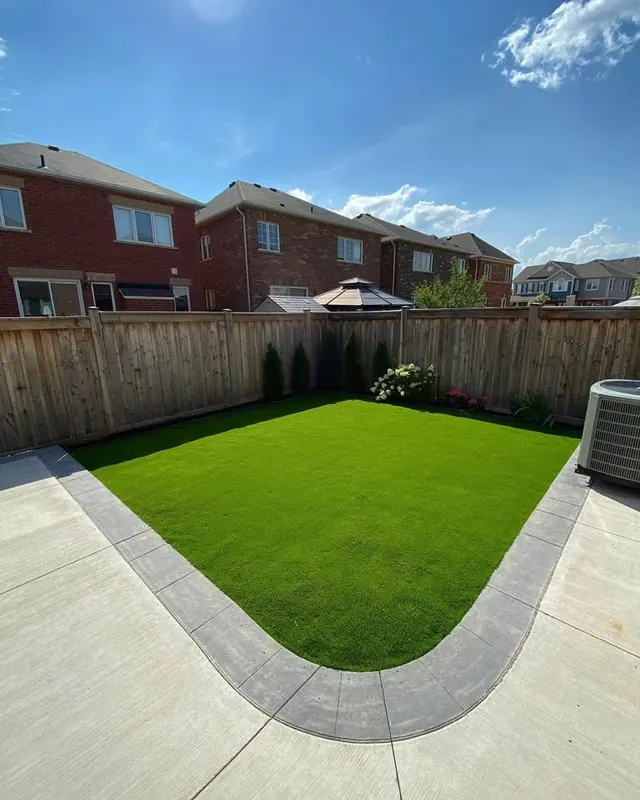 Artificial turf lawn framed by a curved concrete walkway