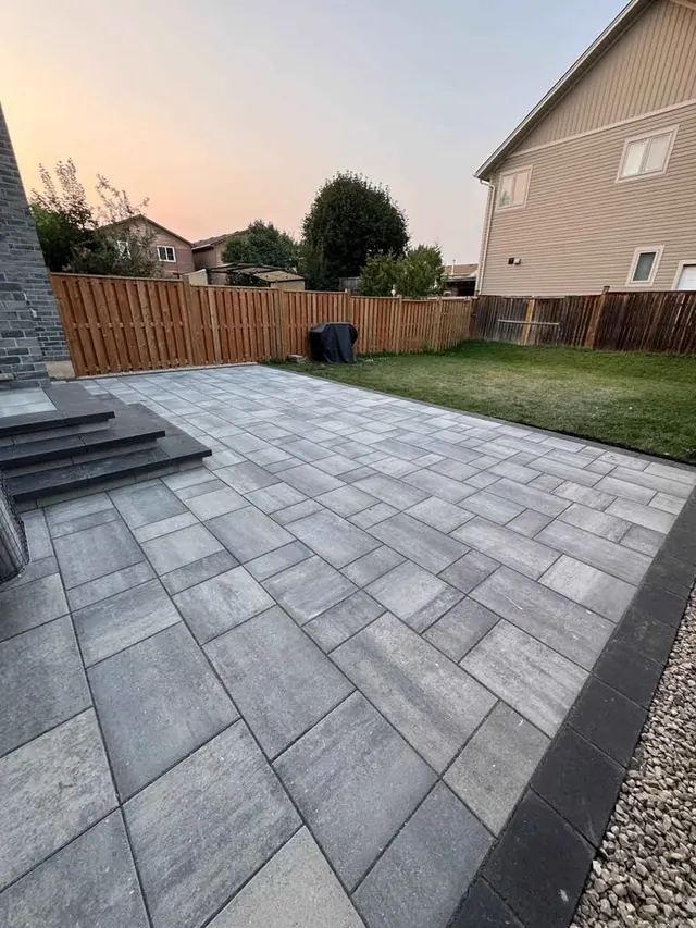 Large-format paver patio running to the fence line