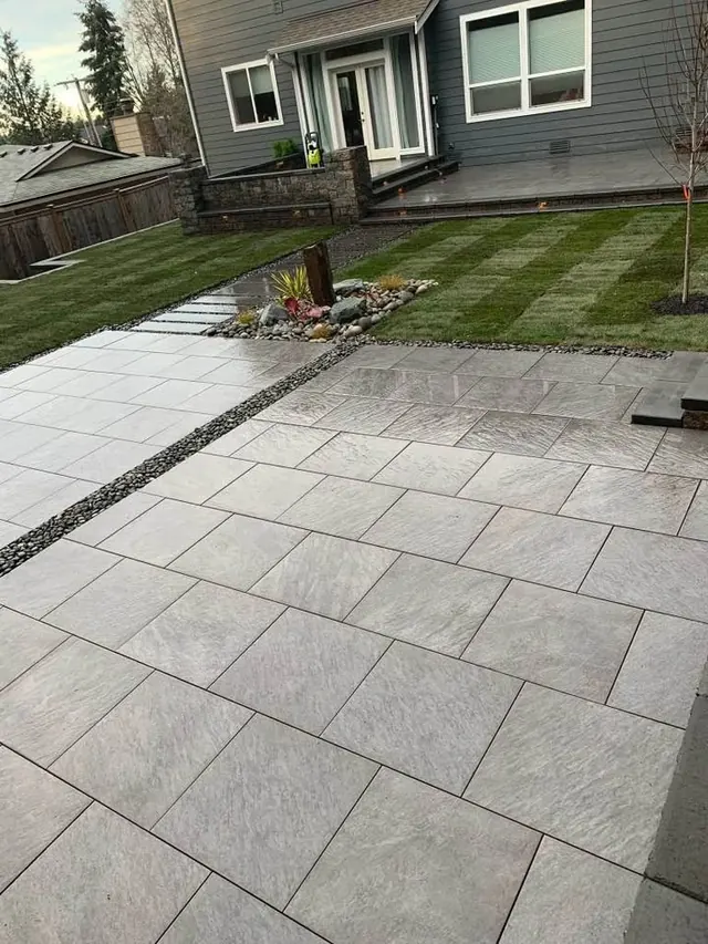 Large-format slab patio along the side of a house
