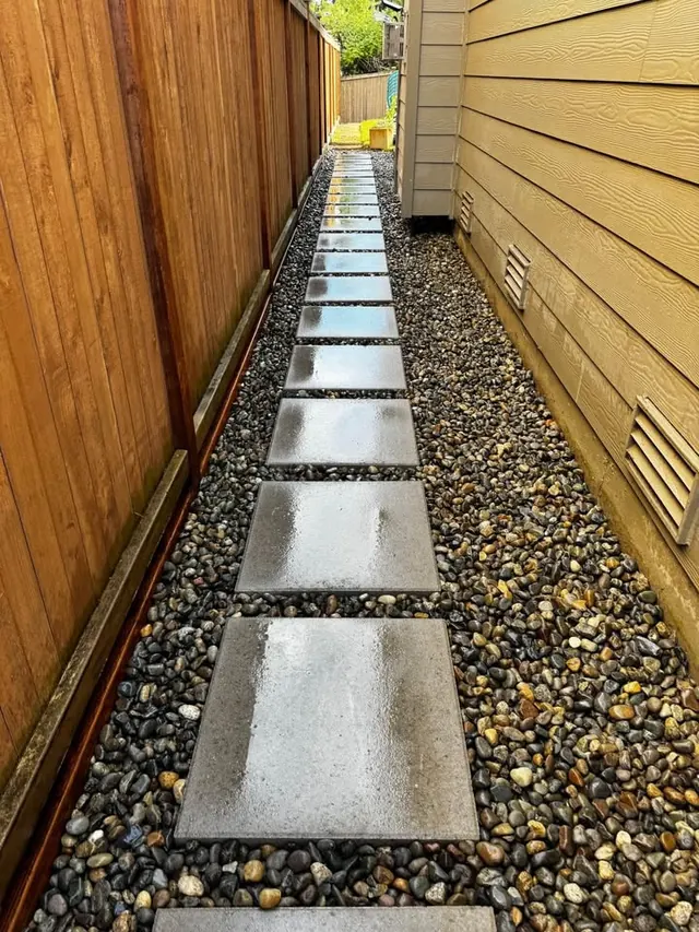 Slab walkway set in river rock down a side yard