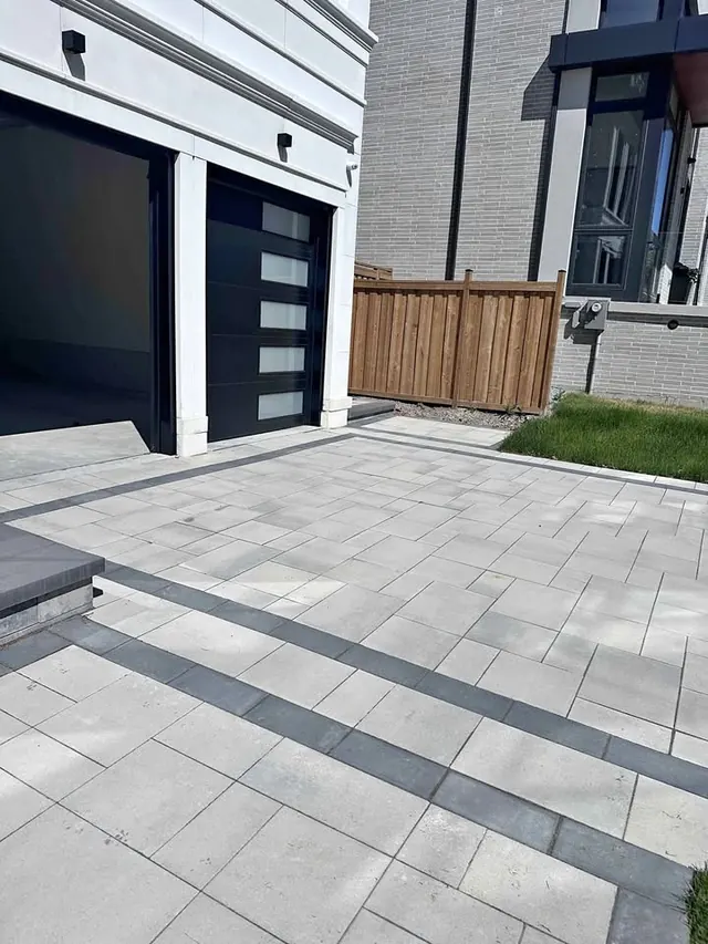 Paver driveway leading to a double garage