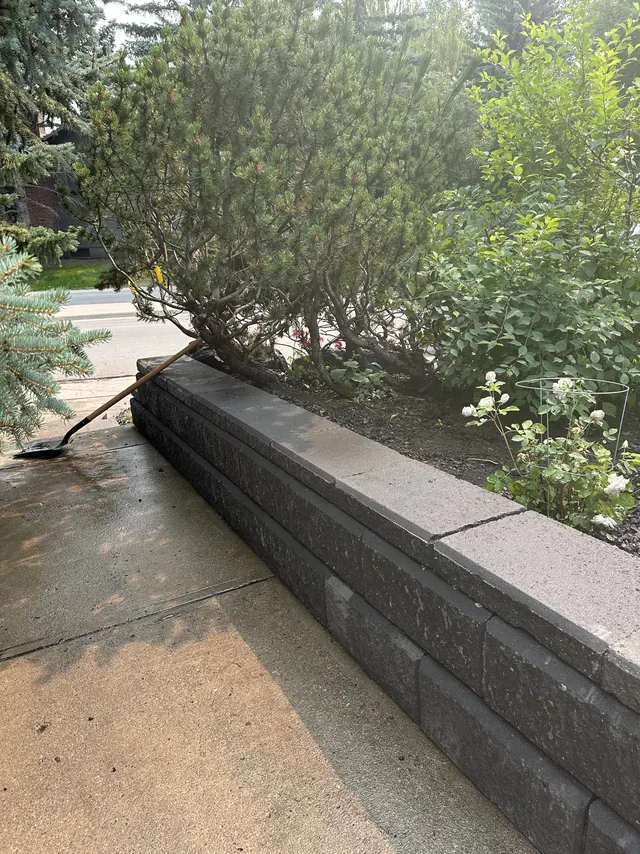 Block retaining wall following the driveway edge