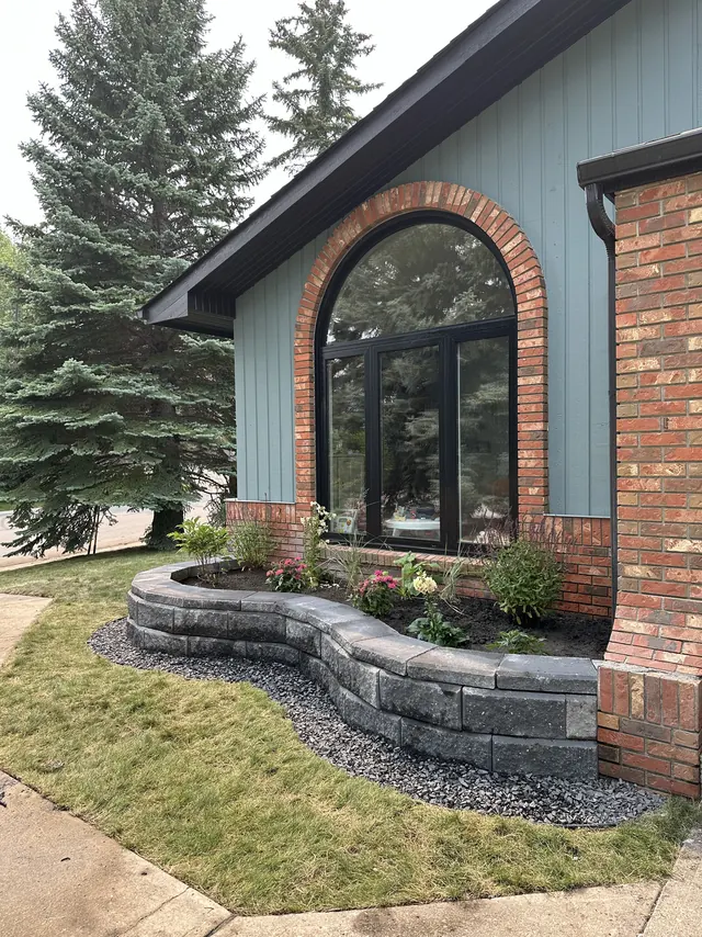 Curved block retaining wall across the front of a house