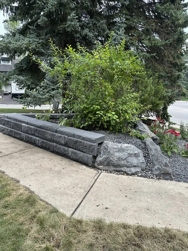 Block retaining wall with a boulder feature